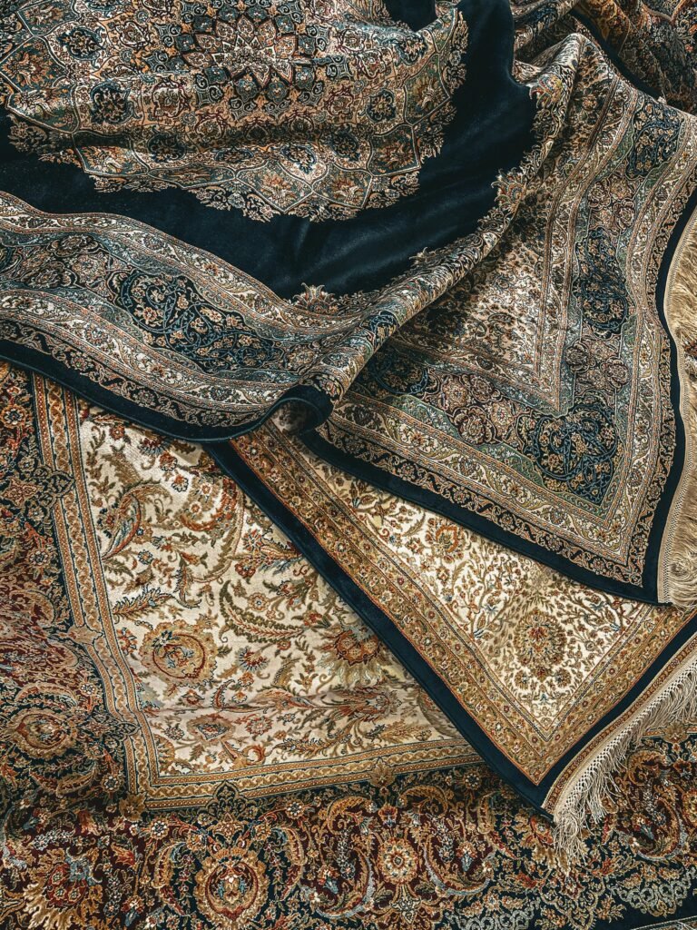 A collection of elegant silk rugs with intricate patterns, showcasing luxury and craftsmanship.